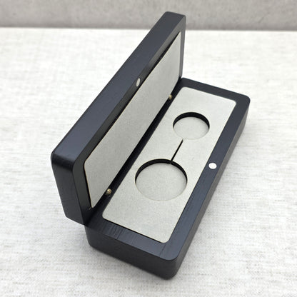 Handcrafted black ash wood gift box open at an angle showing light gray velvet insert with double cutout for keychain or pendant necklace