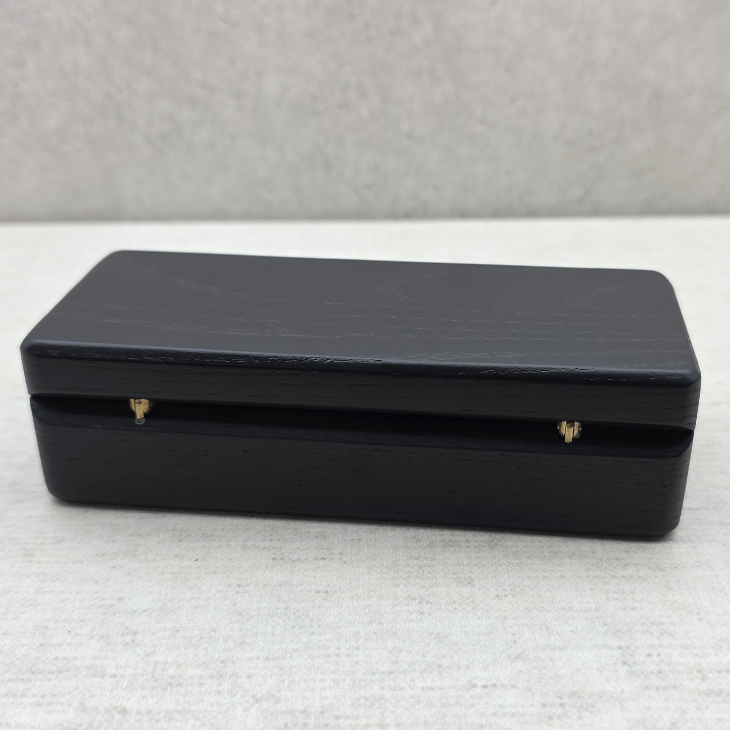 Closed black ash wood presentation box back view showing durable brass hinges