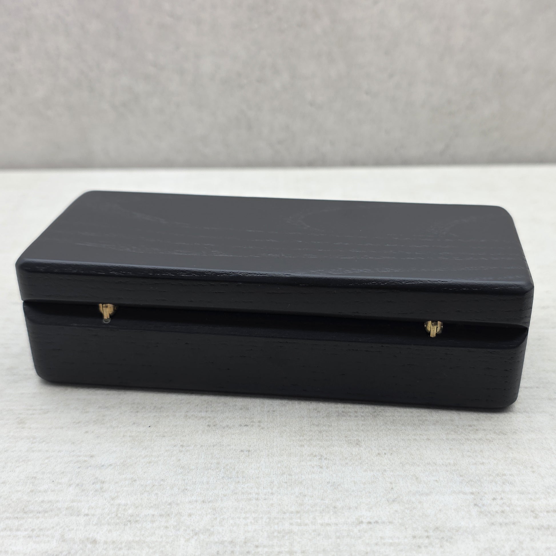 Closed black ash wood presentation box back view showing durable brass hinges