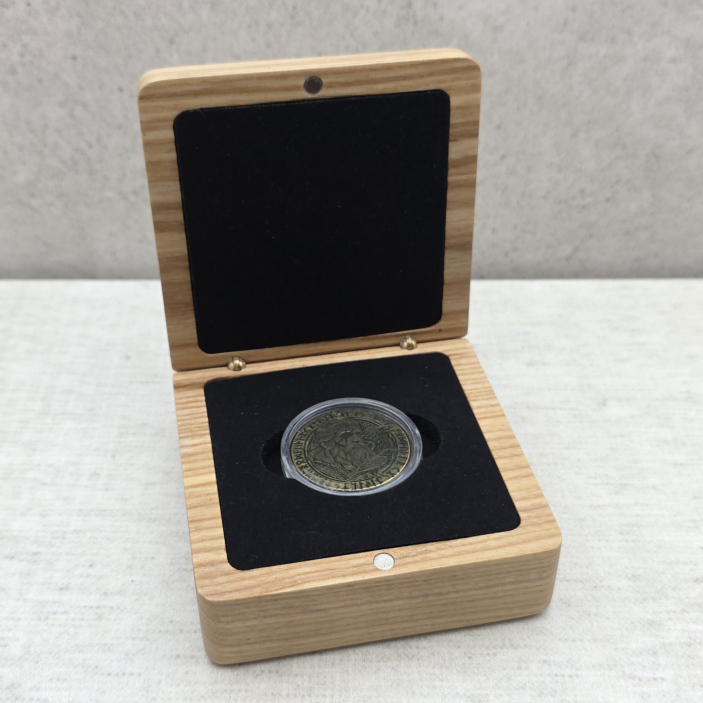 Handcrafted light wood gift box showing custom commemorative coin inside protective capsule on black velvet foam insert.
