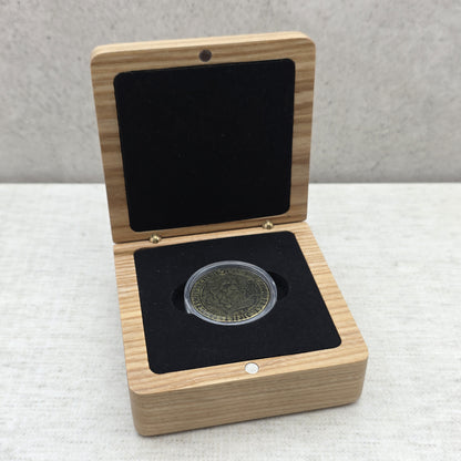 Handcrafted light wood gift box showing custom commemorative coin inside protective capsule on black velvet foam insert.